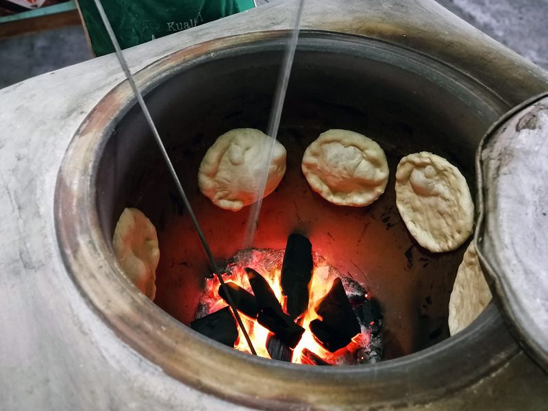 Baking bread on the walls of an oven like structure