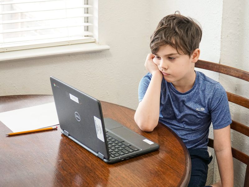 Bored child looking at laptop 
