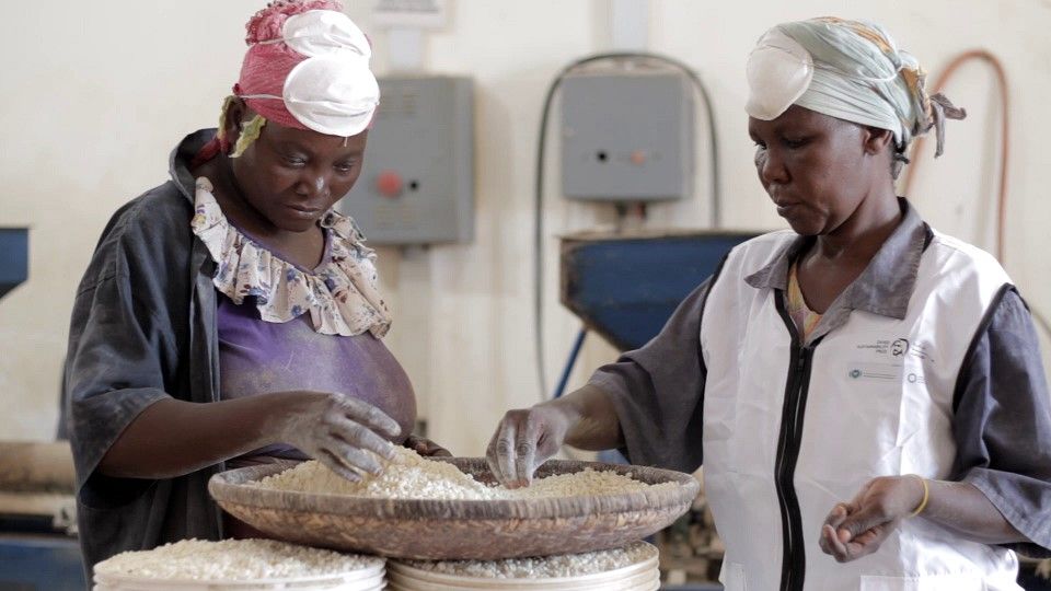 Mill Operator Zahraa Kassim Selemani (left) and Salma Mkopi sift and clean maize at a flourmill in Manzese, Dar es Salaam, Tanzania. 