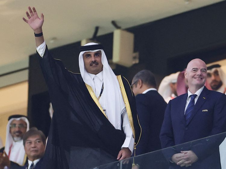 Qatar's Emir Sheikh Tamim bin Hamad Al Thani waves to the crowd as he arrives with FIFA President Gianni Infantino for the Qatar World Cup 2022 Group A football match between Qatar and Ecuador at the Al Bayt Stadium in Al Khor, Doha on November 20, 2022.  