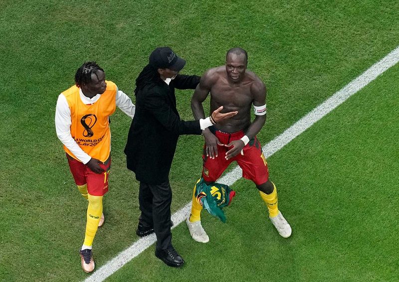 Cameroon's Vincent Aboubakar, right, is congratulated by Cameroon's head coach Rigobert Song 