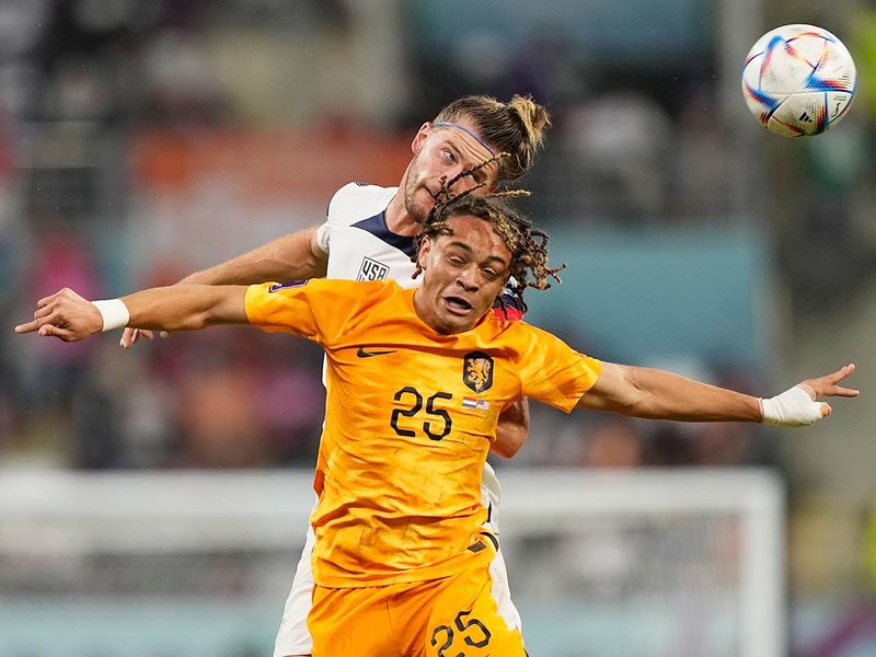 Walker Zimmerman of the United States, background, and Jeremie Frimpong of the Netherlands jump for the ball during the Qatar World Cup round of 16 match, at the Khalifa International Stadium in Doha, Qatar, on Saturday, December 3, 2022. 