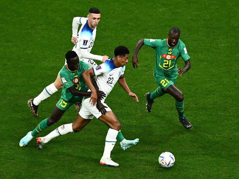 Senegal's forward Krepin Diatta (front L) and defender Youssouf Sabaly (R) fight for the ball with England's forward Phil Foden (rear L) and midfielder Jude Bellingham (C) during the Qatar World Cup round of 16 match at the Al Bayt Stadium in Al Khor, north of Doha. 