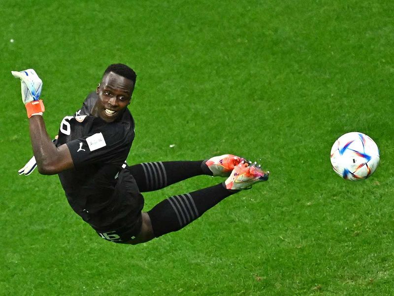 Senegal's goalkeeper Edouard Mendy eyes the ball as he jumps to stop it during the Qatar World Cup round of 16 match against England at the Al Bayt Stadium in Al Khor, north of Doha. 