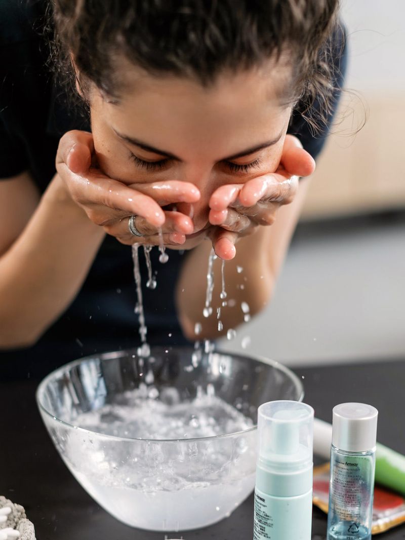 Woman washing her face with cold water before applying makeup 