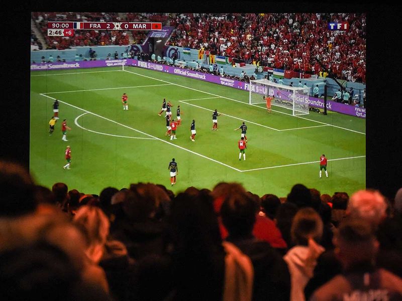 Football fans watch on a giant screen the Qatar 2022 World Cup