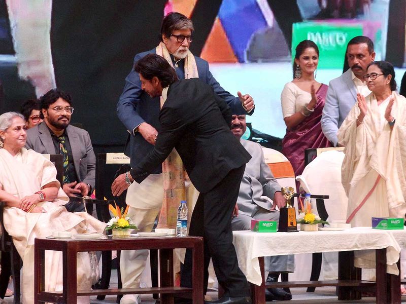 Kolkata, Dec 15 (ANI): Bollywood actor Amitabh Bachchan is being greeted by Shahrukh Khan in presence of his wife Jaya Bachchan, and West Bengal Chief Minister Mamata Banerjee during the inaugural program of the 28th International Kolkata Film Festival, at Netaji Indoor Stadium, in Kolkata on Thursday. (ANI Photo)