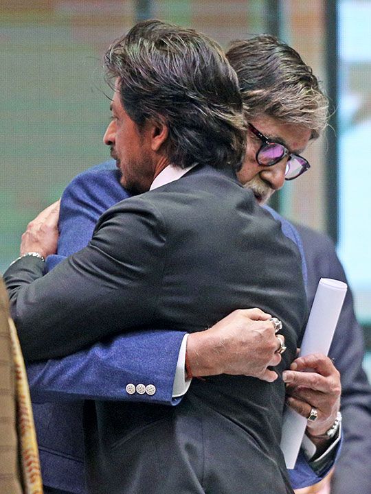 Kolkata, Dec 16 (ANI): Bollywood actors Amitabh Bachchan and Shah Rukh Khan embrace each other during the inaugural programme of the 28th Kolkata International Film Festival, in Kolkata on Thursday. 