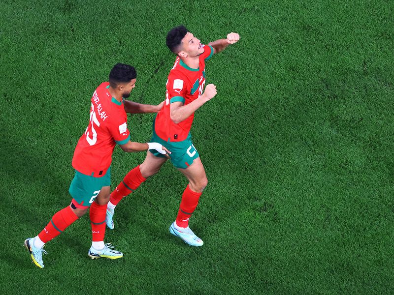Morocco's Achraf Dari (R) celebrates scoring their first goal with Yahya Attiat-Allah. 