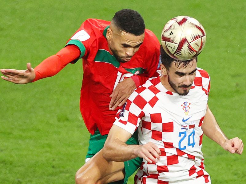 Morocco's forward Youssef En-Nesyri (L) and Croatia's defender Josip Sutalo fight for the ball. 