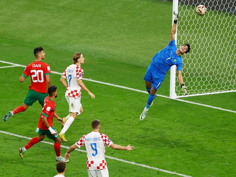 Morocco's goalkeeper Yassine Bounou dives as Mislav Orsic scores Croatia's second goal. 