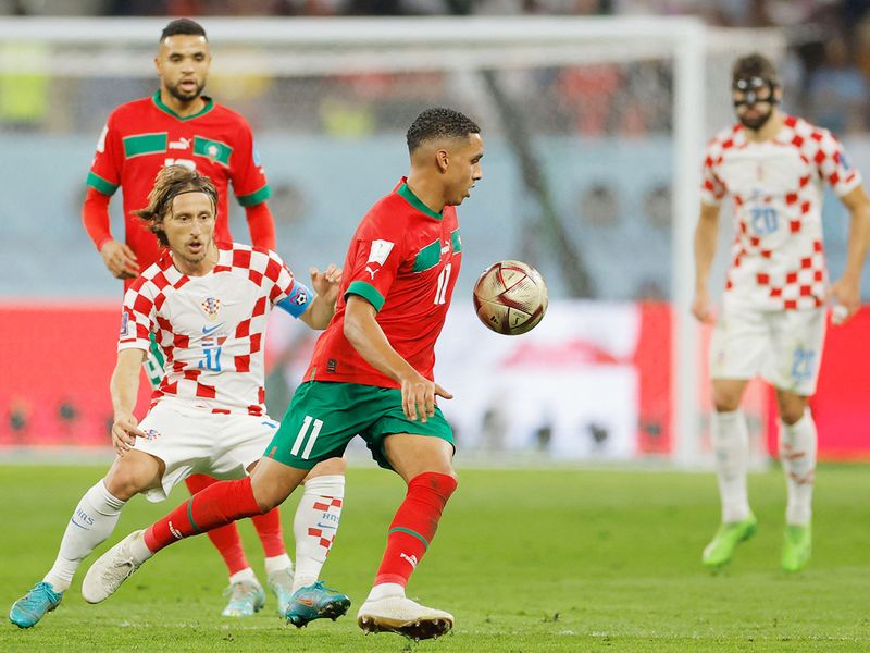 Morocco's midfielder #11 Abdelhamid Sabiri (C) fights for the ball with Croatia's midfielder #10 Luka Modric (L). 