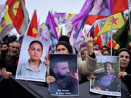Supporters and members of the Kurdish community  hold portraits of victims Emine Kara and Mir Perwer during a demonstration a day after a gunman opened fire at a Kurdish cultural centre killing three people, at The Place de la Republique in Paris on December 24, 2022.  