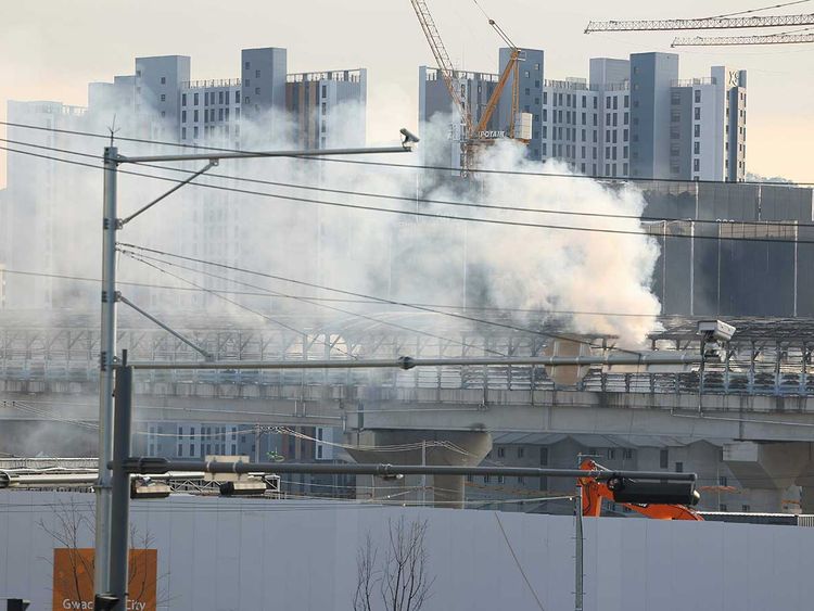 Smoke rises at the scene of a fire in Gwacheon, South Korea, Thursday, Dec. 29, 2022.  A freight truck collided with a bus on a highway near Seoul on Thursday, causing a fire that killed multiple people and injuring dozens of others 