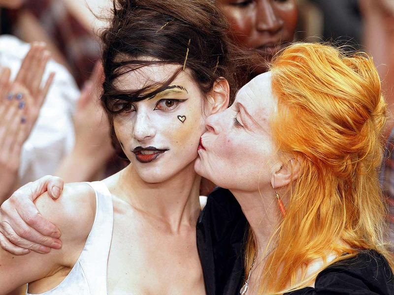  In this file photo taken on October 1, 2010 British designer Vivienne Westwood (R) kisses the cheek of a model who presents her creations during the Spring/Summer 2011 ready-to-wear collection show in Paris.