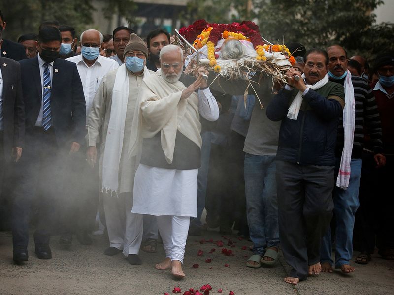 Indian Prime Minister Narendra Modi carries the body of his mother Heeraben at a crematorium in Gandhinagar, India, December 30, 2022.