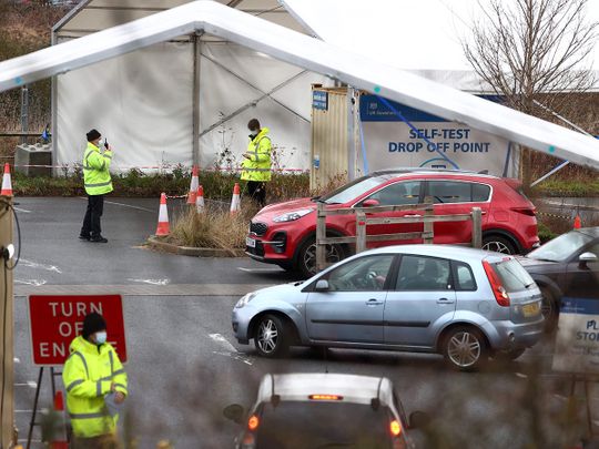 NHS workers assist members of the public as they drive into a COVID-19 test centre close to the Royal Surrey County hospital in Guildford, southern England.