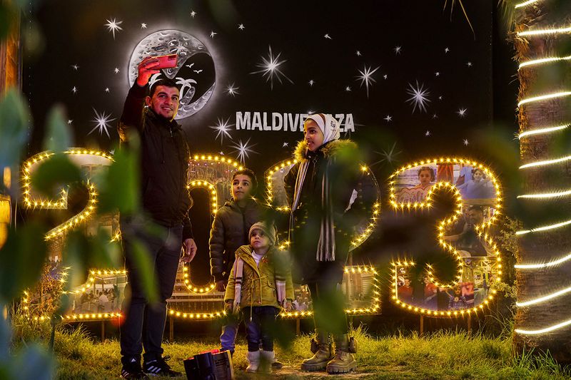 A Palestinian family takes selfie near a lit 2023 sign ahead of New Year celebrations, in Gaza City 