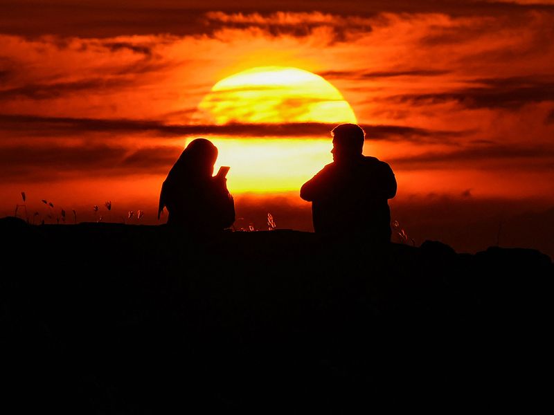 A couple look at the last sunset on year of 2022 at Lhoknga beach, Indonesia's Aceh province  