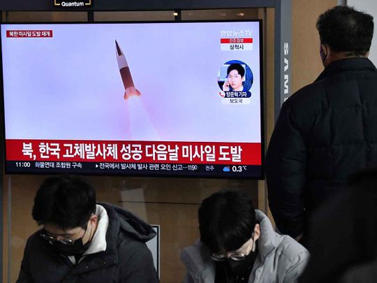 A man watches a television screen showing a news broadcast with file footage of a North Korean missile test, at a railway station in Seoul on December 31, 2022 after North Korea fired three short-range ballistic missiles according to South Korea's military.