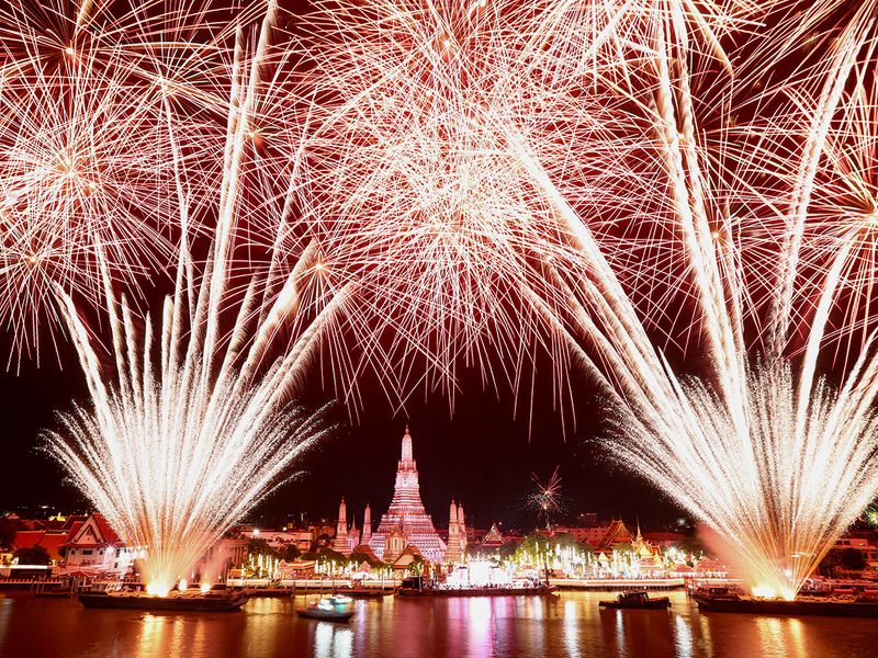 Fireworks explode over the Chao Phraya River during the New Year celebrations, in Bangkok, Thailand