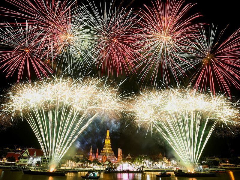 Fireworks explode over the Chao Phraya River during the New Year celebrations, in Bangkok, Thailand