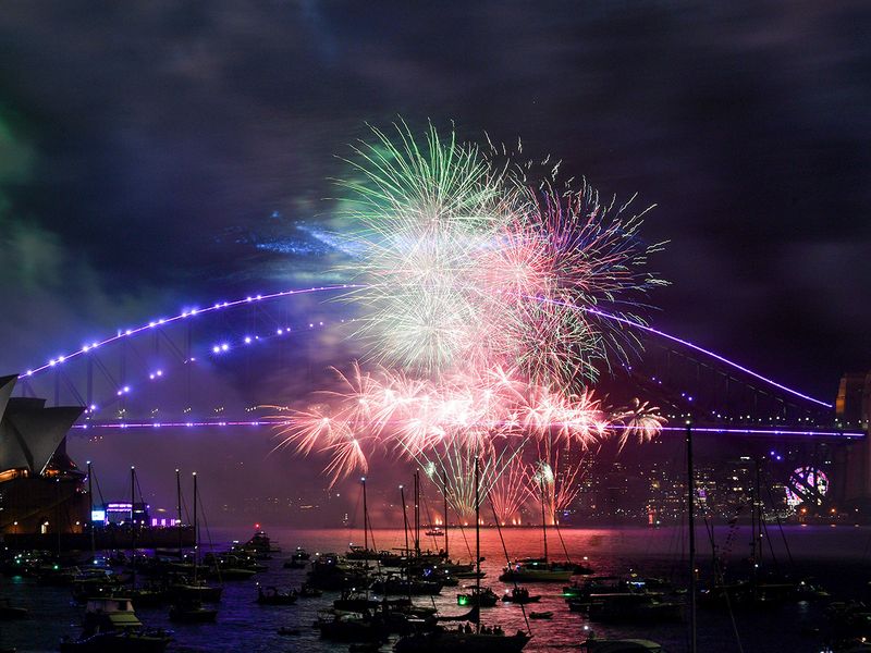 Fireworks explode over the Sydney Harbour Bridge during an early fireworks show ahead of New Year celebrations in Sydney