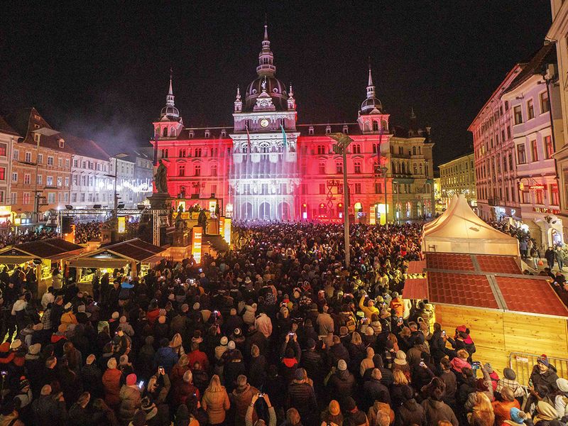 Hundreds of tourists and citizens attend a water and laser show to celebrate the New Year on the main square in Graz, Austria 