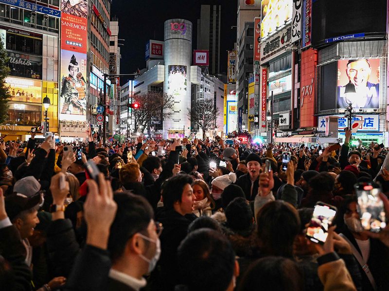 People celebrate the start of New Year’s Day at midnight at Shibuya Crossing in Tokyo 