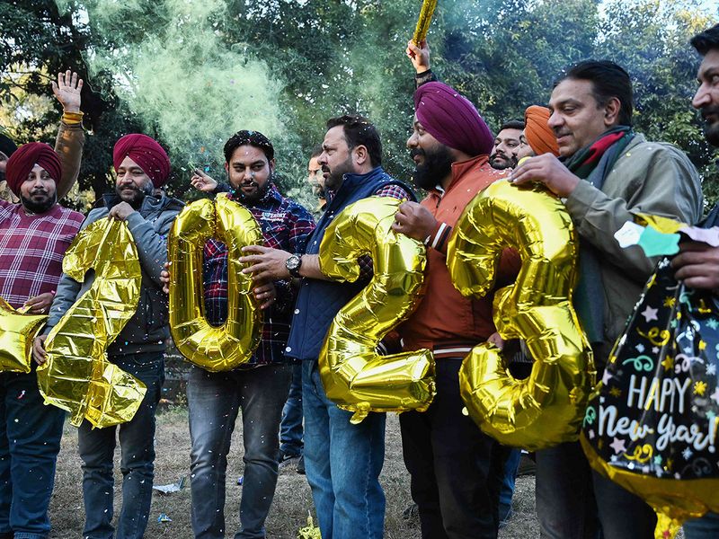 People hold numeric shaped balloons during celebrations on the eve of New Year in Amritsar, India