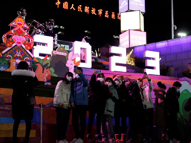 People pose for pictures with a 2023 installation at a shopping complex on New Year's Eve, in Beijing, China 