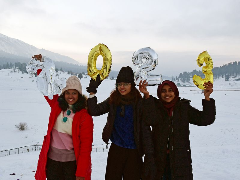 Tourists pose for a photo at the Gulmarg Ski Resort on New Year's eve, in Baramulla, Kashmir, India