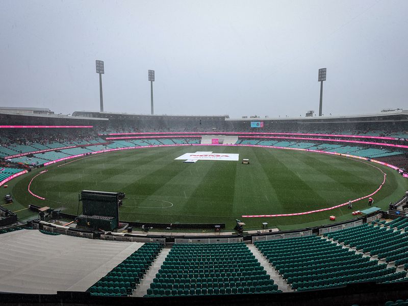 Rain falls on the ground with covers over the pitch on day three of the third Test match between Australia and South Africa at the Sydney Cricket Ground (SCG) in Sydney on January 6, 2023.  