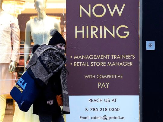 A hiring sign is displayed at a retail store in Chicago.