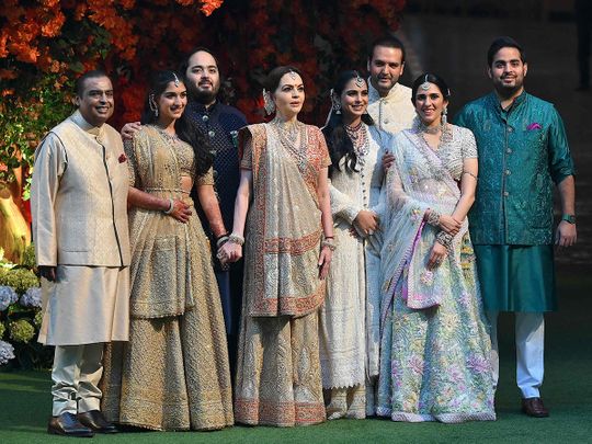 Indian billionaire Mukesh Ambani (L) along with his wife Nita (4L) pose with their elder son Akash (R) his wife Shloka (2R), daughter Isha (4R) her husband Anand Piramal (3R) and younger son Anant (3L) his fiancée Radhika Merchant (2L) during Anant's engagement ceremony in Mumbai on January 19, 2023. 