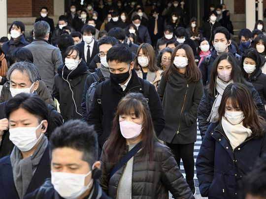 Commuters wear masks outside Tokyo Station in Tokyo on Friday, January 20, 2023. 