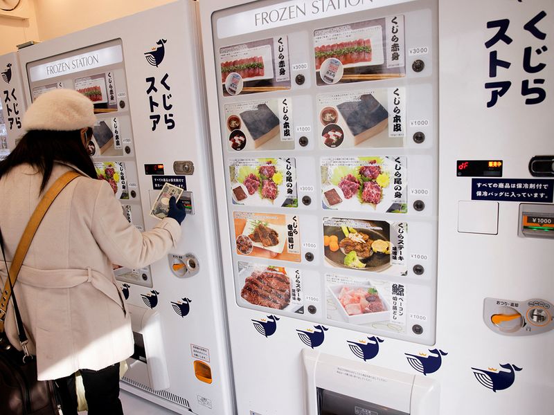 A customer buys whale meat on the opening day of the shop by a Japanese whale-hunting company with vending machines, in Yokohama. 