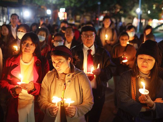 People hold candles during a candlelight vigil for the victims 
