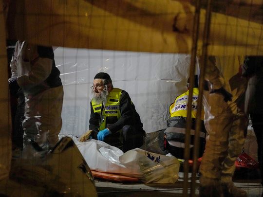 Members of Zaka Rescue and Recovery team check victims of a shooting attack near a synagogue in Jerusalem, on Friday, January 27, 2023. 