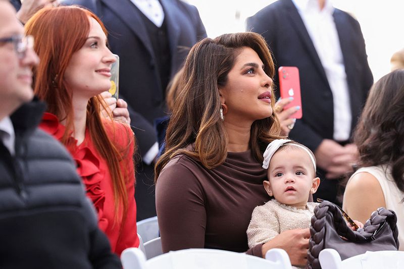 Priyanka Chopra holds her and Nick Jonas' daughter, Malti, as Sophie Turner, Joe Jonas' wife looks on, during the ceremony where the Jonas Brothers will unveil their star on The Hollywood Walk of Fame in Los Angeles, California, U.S., January 30, 2023.