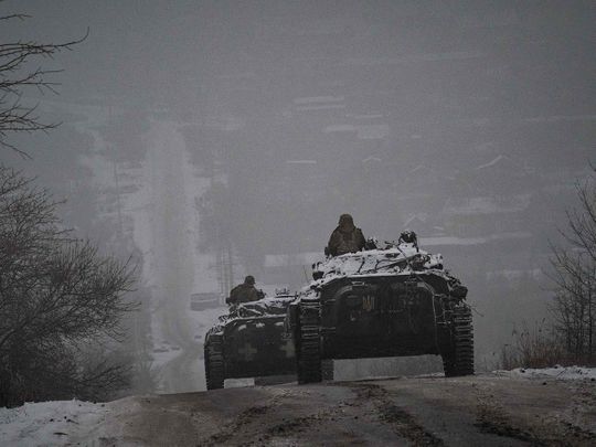 Ukrainian servicemen ride atop BMP-2 infantry combat vehicles
