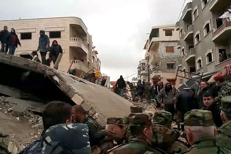 A still image from video, released by Russia's Defence Ministry, shows people including Russian military personnel involved in a search and rescue operation after a devastating earthquake in the region of Latakia, Syria, in this image taken from handout footage released February 7, 2023. 