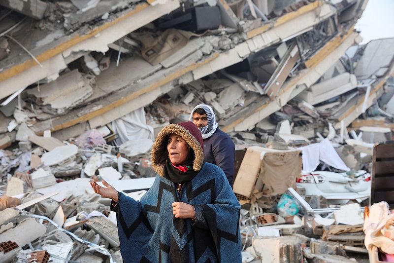 A woman reacts while standing amid rubble, following an earthquake in Hatay, Turkey, February 7, 2023. 