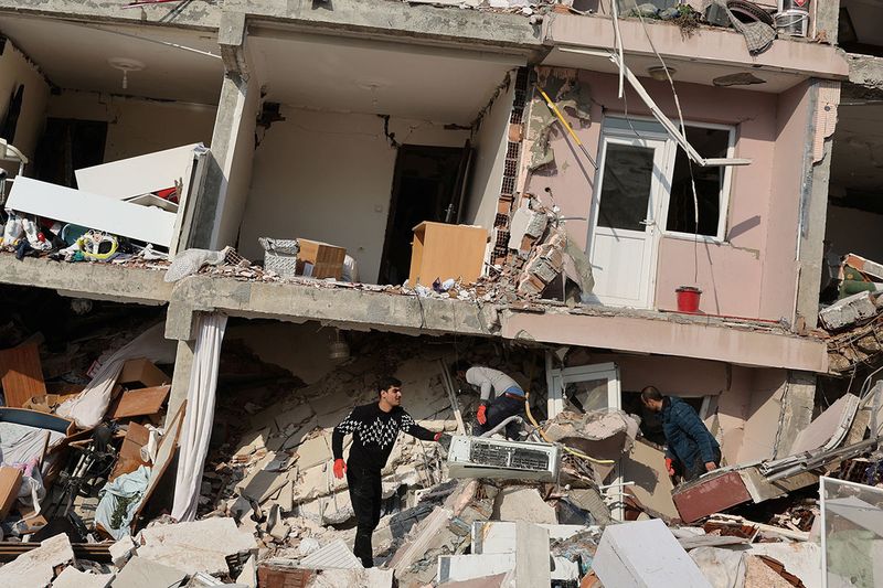 People look amid rubble as the search for survivors continues following an earthquake in Hatay, Turkey, February 7, 2023.