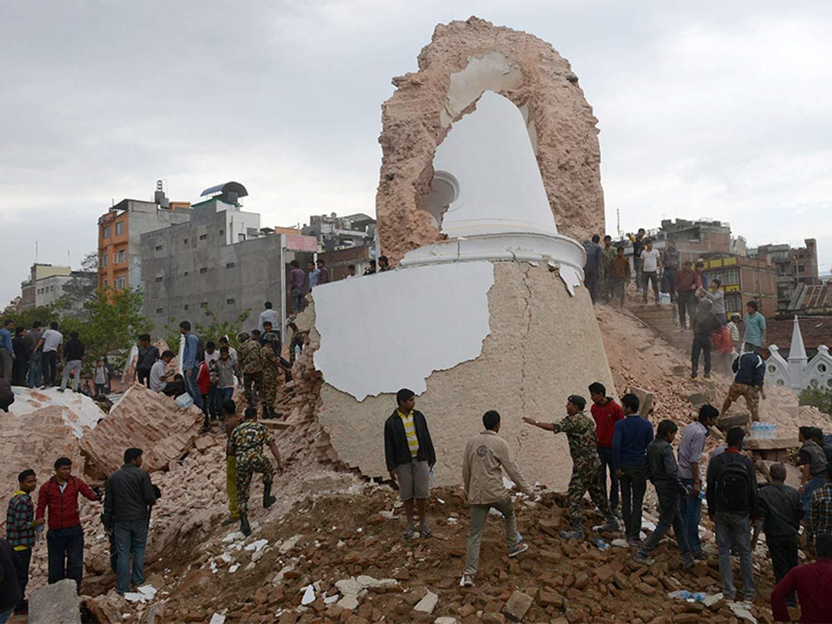 Nepalese rescue members and onlookers gather at the collapsed Darahara Tower in Kathmandu on April 25, 2015.