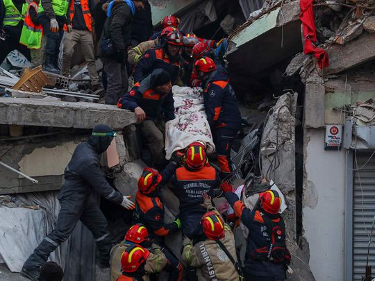 Turkish rescue workers carry Ergin Guzeloglan, 36, to an ambulance after pulled him out from a collapsed building five days after the earthquake, in Hatay, southern Turkey, early Saturday, Feb. 11, 2023. 