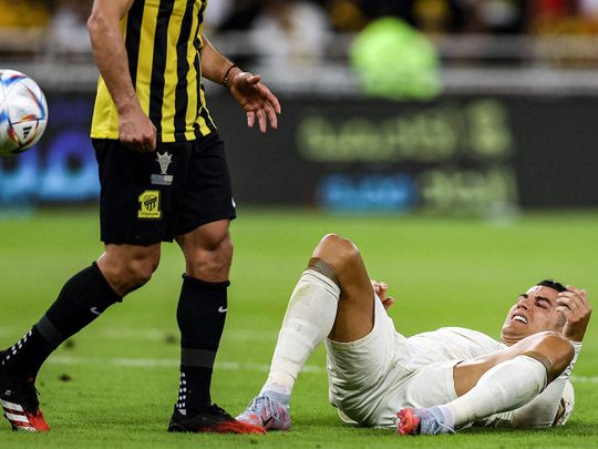 Al Nassr's Portuguese forward Cristiano Ronaldo reacts while on the ground during the Saudi Pro League football match between Al Ittihad and Al Nassr at King Abdullah Sport City Stadium in Jeddah on March 9, 2023. 