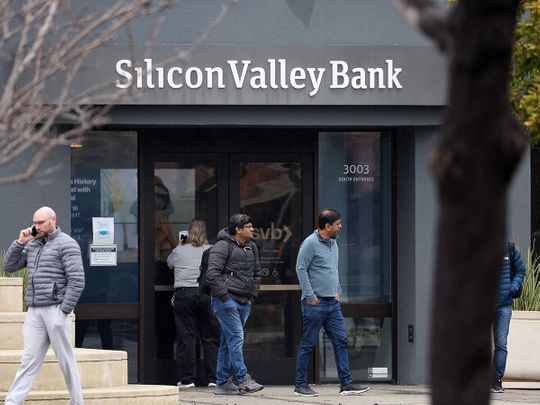Employees stand outside of the shuttered Silicon Valley Bank (SVB) headquarters on March 10, 2023 in Santa Clara, California.