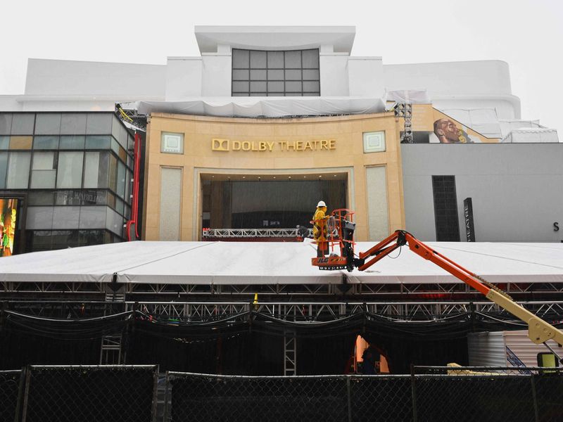 A worker operates a cherry-picker in the rain as final touches are made for the Oscars ceremony at Los Angeles in US.