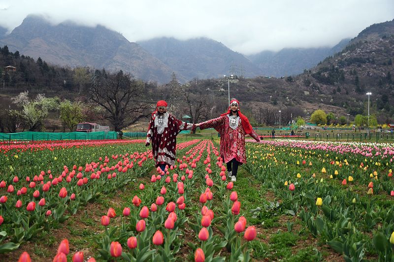  Women dressed in tradtional Kashmiri attire poses for a photo at Siraj Bagh, Tulip Garden, after it has been open for the public, in Srinagar on Sunday.